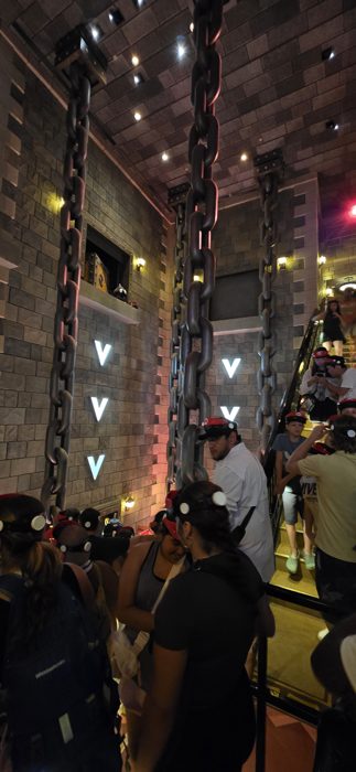 The crew shuffling up the stone staircase toward the ride vehicles.