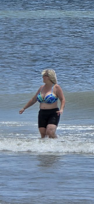 Wading out through the surf on a bright beach afternoon.