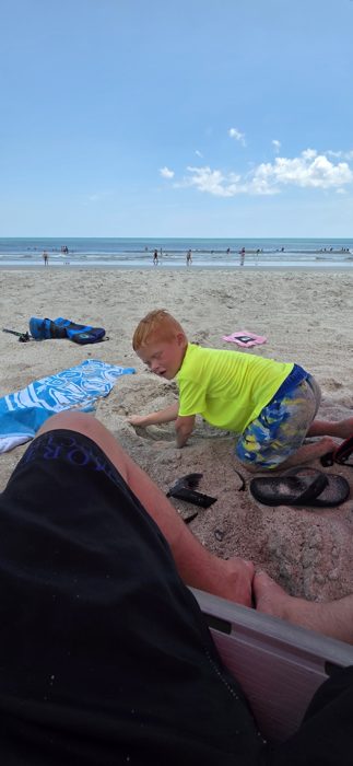 Deep in concentration digging a hole in the sand.