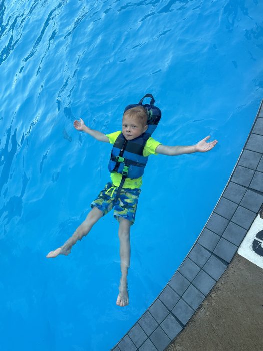 One of the kids floats back in his life vest for some evening pool time.