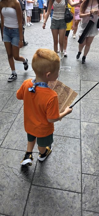 Map in one hand and wand in the other, one of the kids navigates the crowds of Diagon Alley.