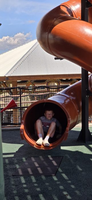 Racing down the spiral tube slide at the playground above the gorge.