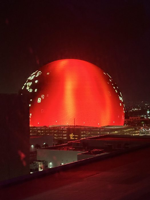 The glowing Las Vegas Sphere lit up bright orange — a wild roadside spectacle on the drive west.