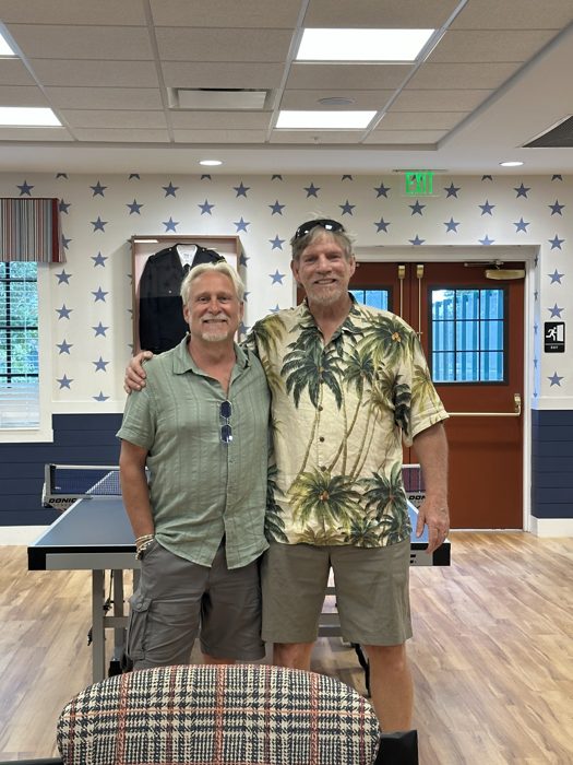 Reuniting with an old friend in the resort clubhouse, its walls lined with fire and police department mementos.