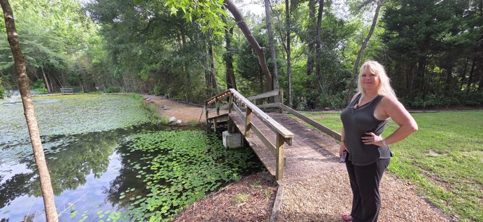 One of us pauses on a morning walk along the campground's lily-pad pond and wooden footbridge.