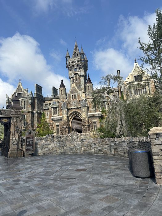 The full gothic castle rises against a bright blue sky, quiet before the crowds arrive.