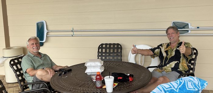 Two of us kick back poolside with lunch, throwing up a big thumbs-up for the afternoon.