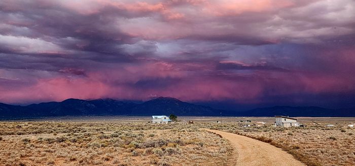 A vivid purple-and-rose sunset crowns the mountains above our desert boondock.