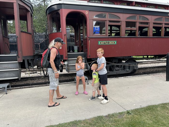 The whole family lined up alongside the gleaming maroon coaches before climbing aboard the 1880 Train in the Black Hills.