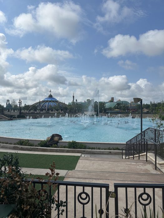 The park's fountain lagoon stretches out beneath a sky full of billowing clouds.