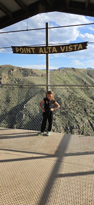 Standing beneath the Point Alta Vista banner at the canyon overlook.