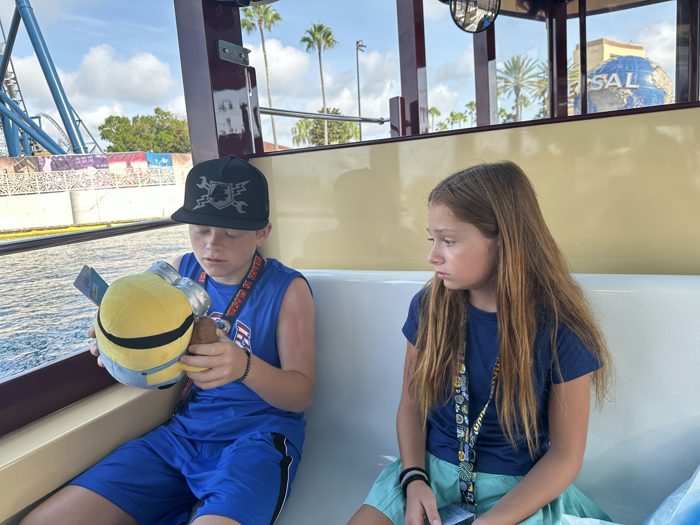 Cruising the lagoon on the water taxi, one of the kids studying a new Minion plush while the other looks on.