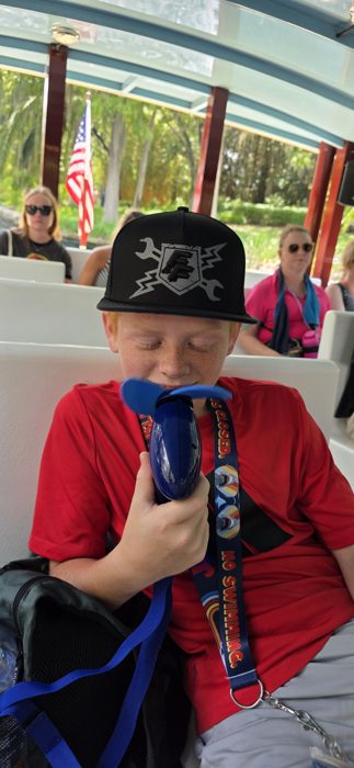 Eyes closed and savoring the breeze from a handheld fan on the water taxi.