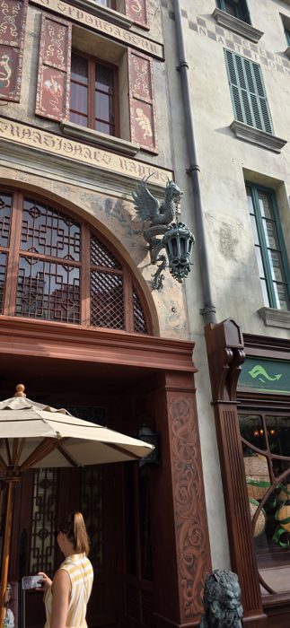 One of the family pauses to photograph the griffin lamp guarding a shop entrance.
