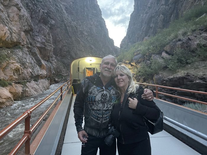 The two of us grinning in the open-air car with sheer canyon walls soaring behind us.