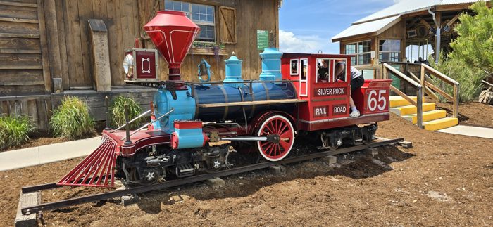 The bright vintage train and engine display near the play area.
