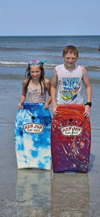 The kids show off matching Ron Jon boogie boards before heading back out to catch some waves.