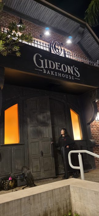 One of the group heads in through Gideon's heavy wooden doors, its windows glowing orange from within.