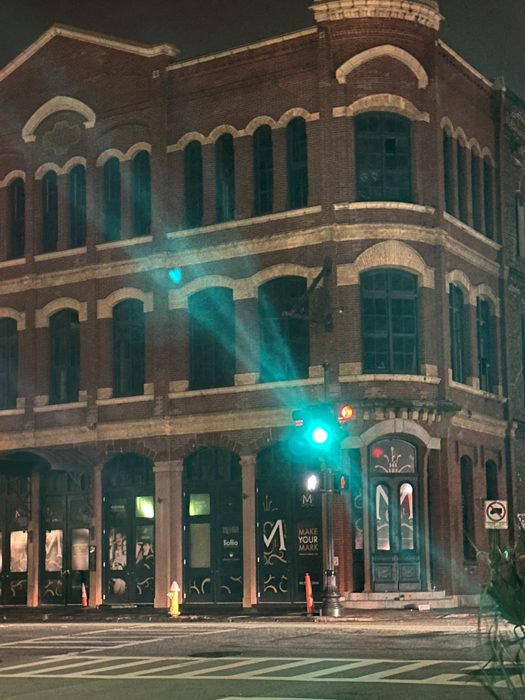 Charleston's colorful historic storefronts lit up against the night sky.