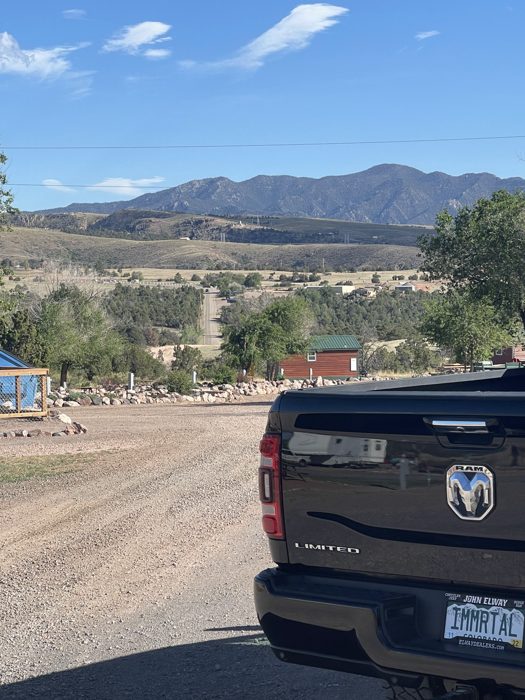Our truck parked at the dusty campground lot with the foothills rising behind it.