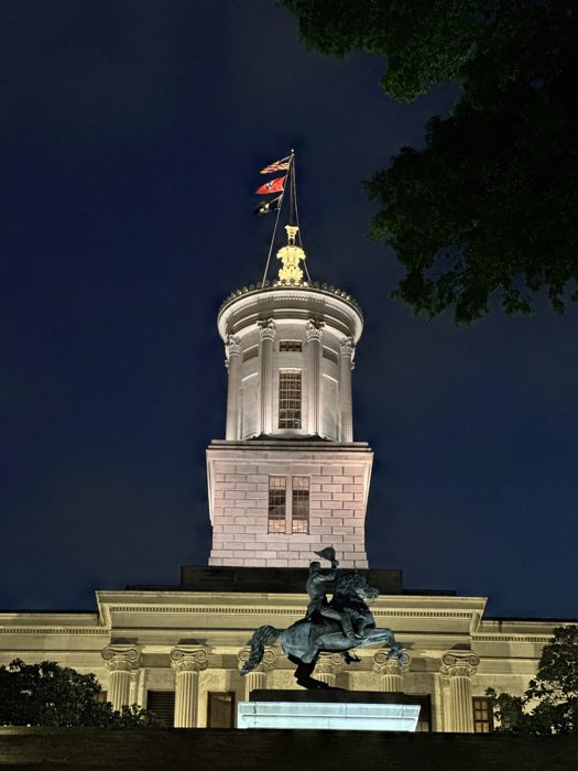 The Tennessee State Capitol lit up against a deep blue evening sky.