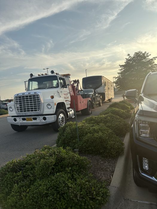 The wrecker pulls our truck and trailer out of the dealership lot as evening sets in.
