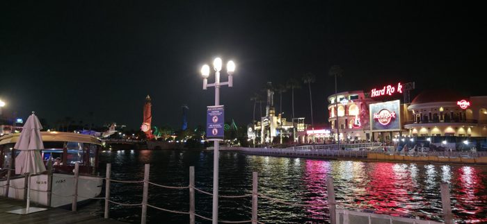 CityWalk's lights spill across the water with the Hard Rock Cafe glowing on the far shore.