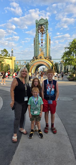 A last family shot at the Epic Universe entrance, everyone still all smiles in the early morning light.