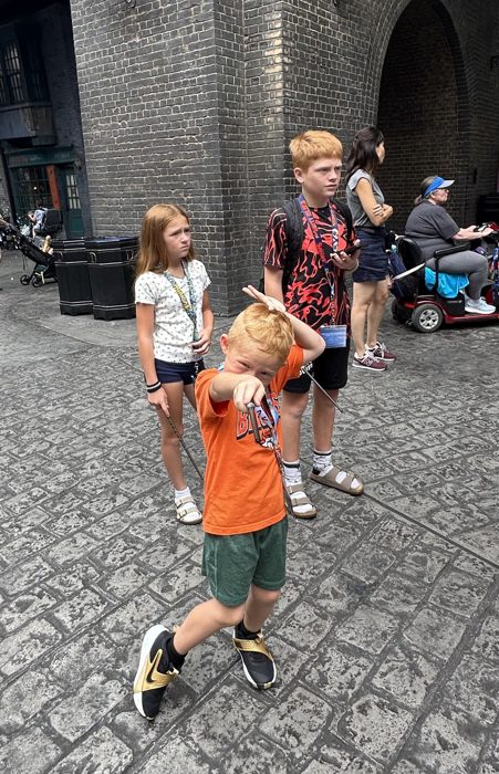 A triumphant wand-pointing pose after casting a spell.