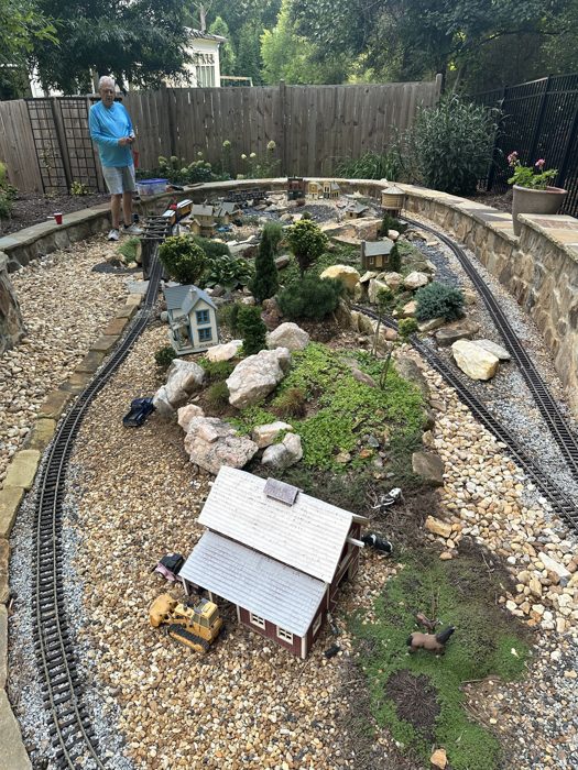 A closer look at the backyard garden railroad, tiny towns and trestle bridges tucked among the rocks.