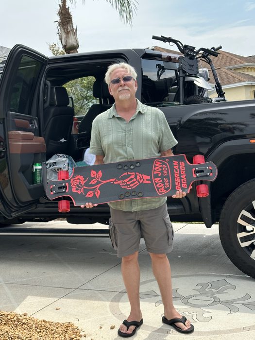 A closer look at the new red-and-black longboard before it goes in the truck bed.