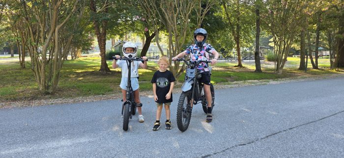 All three kids geared up and ready to roll on the e-bikes.