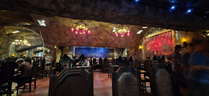Settling into the cave-like dining room at the park's monster-themed restaurant, red lanterns glowing overhead.
