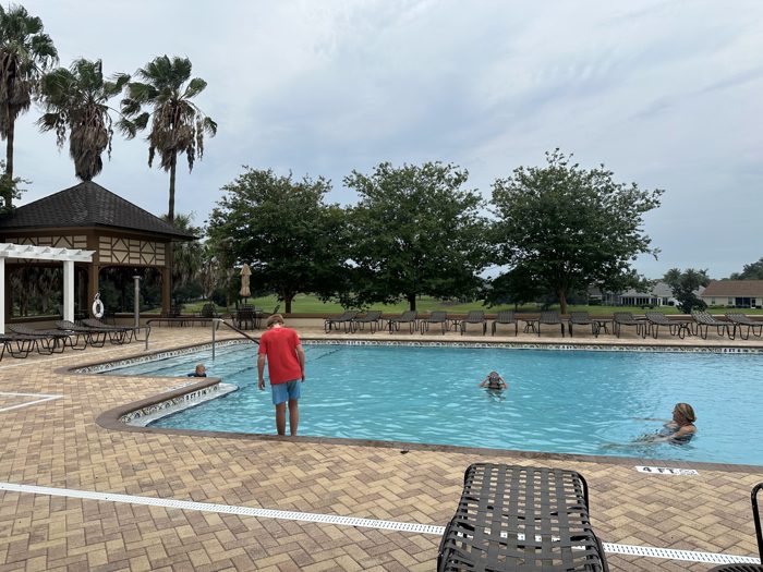The kids wade and swim in the resort pool under a moody Florida sky.