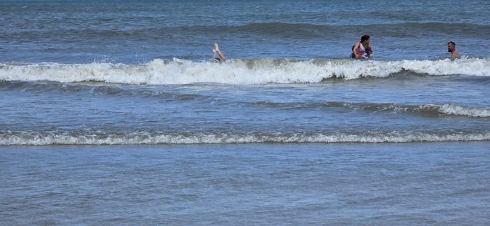 One of the kids catches a wave headfirst as the family cools off in the surf.