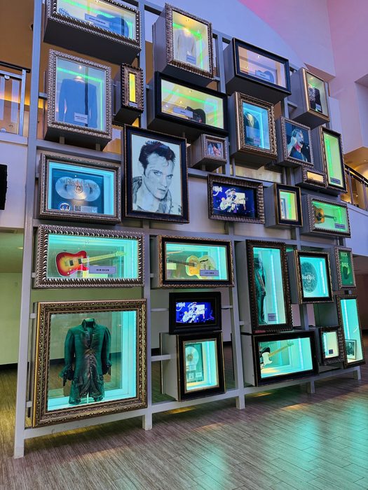 The Hard Rock's signature wall of backlit framed memorabilia and instruments.