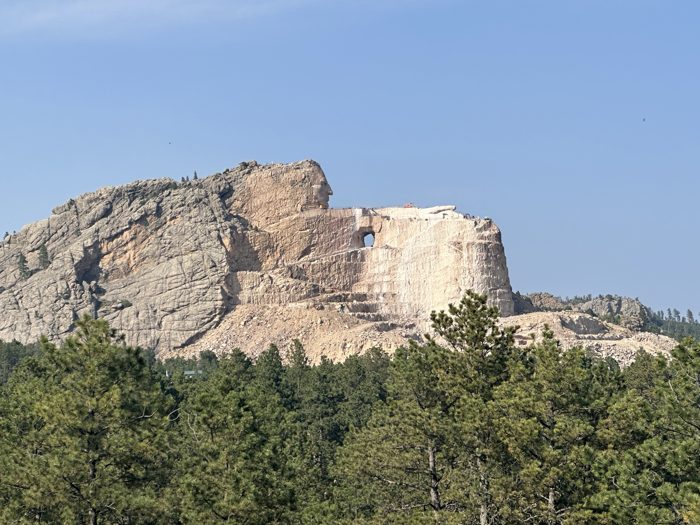 The Crazy Horse Memorial rises out of the hills in the distance.