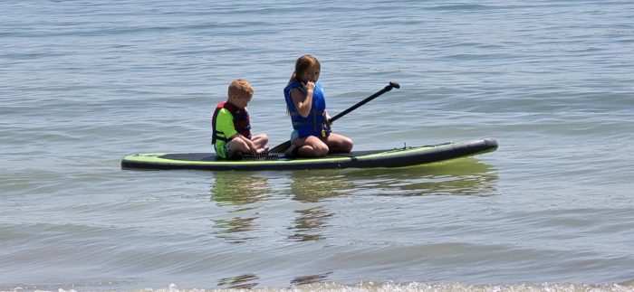 Two of the kids share a paddleboard out on the calm water of Boyd Lake.