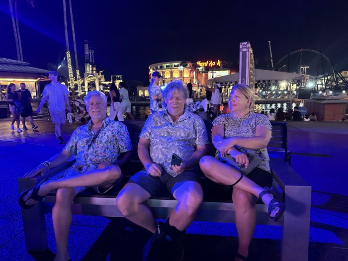 Taking a break on a bench along CityWalk, the Hard Rock sign glowing blue in the night behind us.