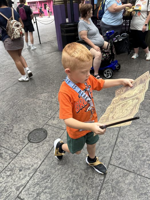 Studying the map for the next stop while the wand waits at the ready.