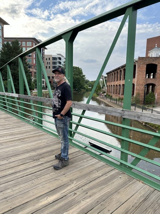 Dad out on the green steel truss footbridge over the river.