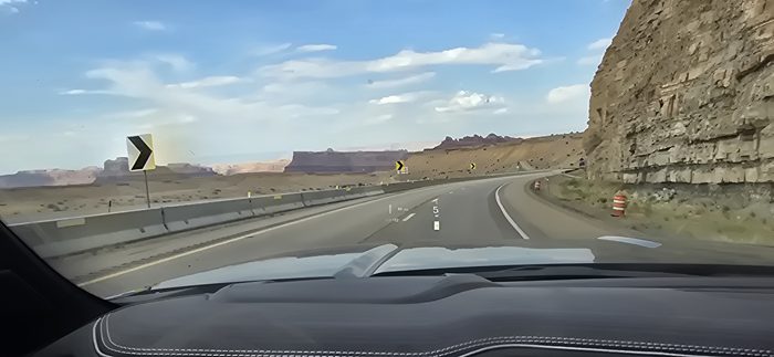 Cruising the highway as the red rock canyons of Utah rise up alongside us.