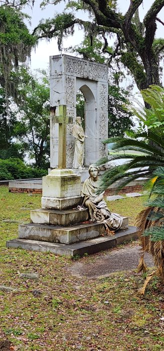 A robed memorial statue stands guard among the palms and live oaks of Bonaventure.