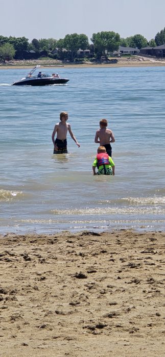 Wading out into Boyd Lake as a boat cruises past in the distance.
