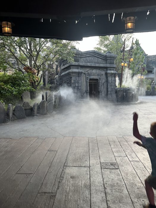 Ducking under the covered walkway as fog spills across the courtyard ahead.