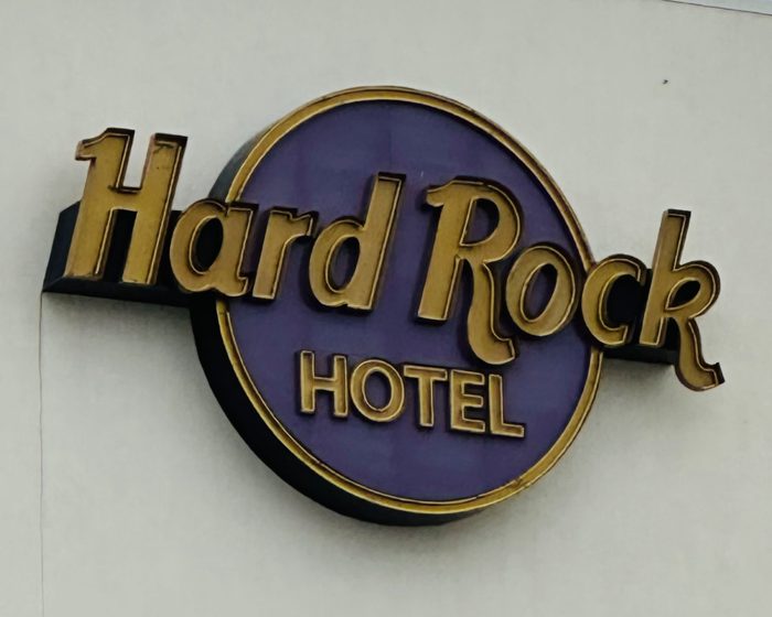 The Hard Rock Hotel sign gleaming in gold against a rich purple backdrop.