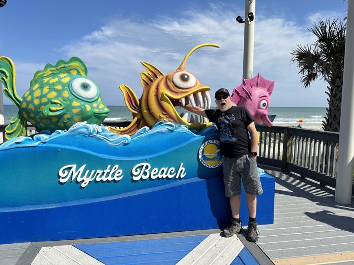 Posing with the playful sea-creature bench on the Myrtle Beach boardwalk.