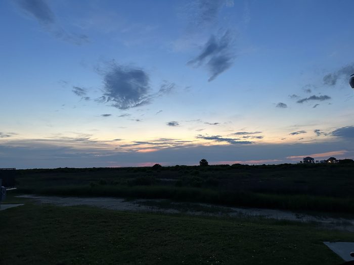 Soft dusk colors spreading across the wide sky over the coastal flats.