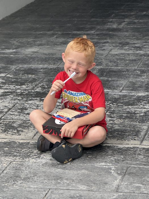 One of the kids multitasks with a toothbrush and a pastry outside the hotel this morning.