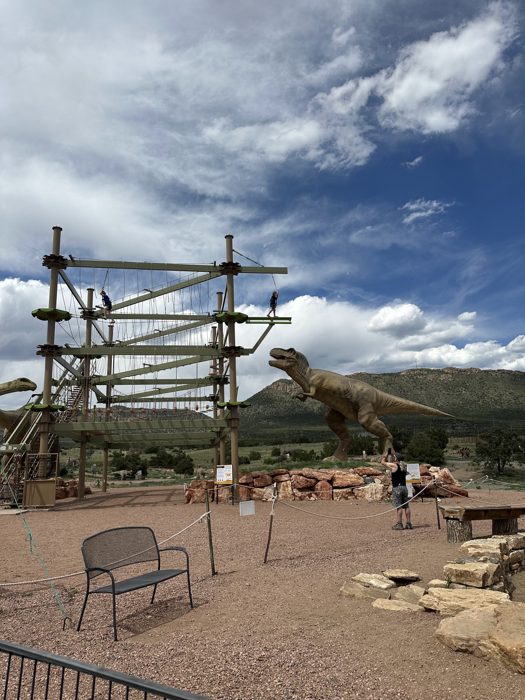 A toothy dinosaur statue keeping watch over the adventure park.